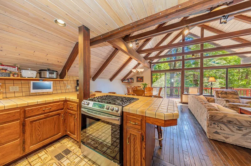 The kitchen, open to the living room and the A-frame's windows