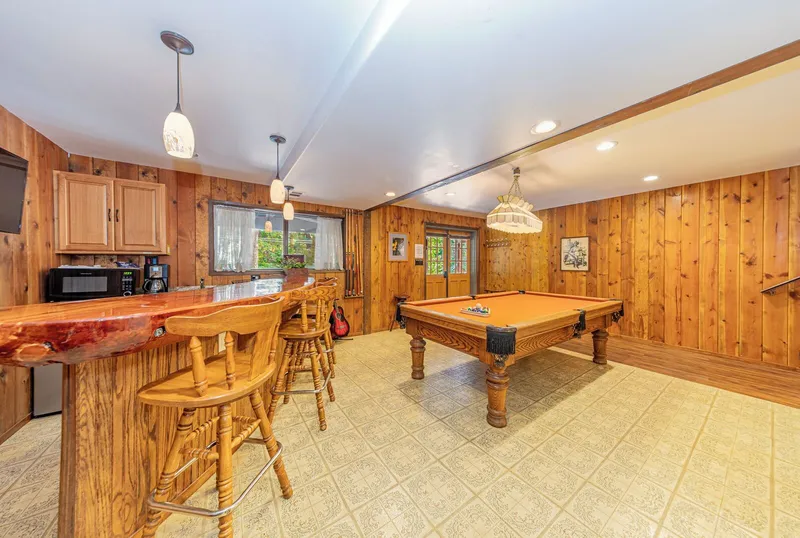 The game room: the burl wood bar and its stools, and the pool table