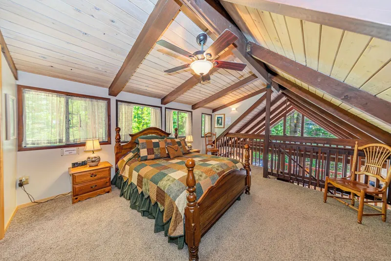 The top floor's bedroom, its four-poster bed and the railing over the living room